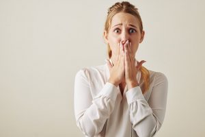 Awoman with her hands covering her hads and nose, something you should avoid with germs.