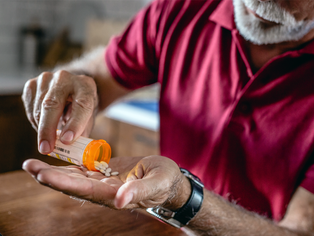 Person pouring antibiotics in had from a pill bottle, Taking antibiotics increases your chance of contracting C. diff