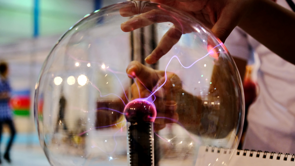 A person is touching and electrostatic precipitator and lightning bolts are forming from center to the person's fingers .