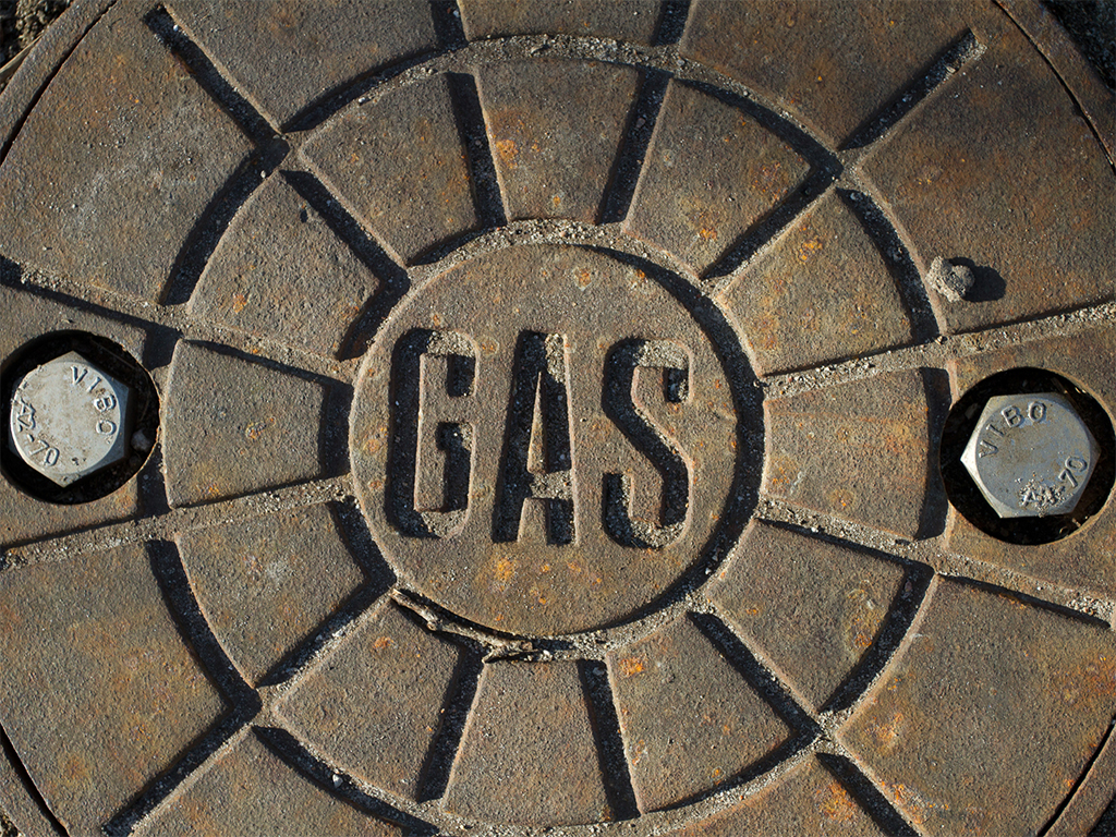 Manhole cover with the word gas, air is a gas and can be stripped of VOCs with an appropriate air purifier