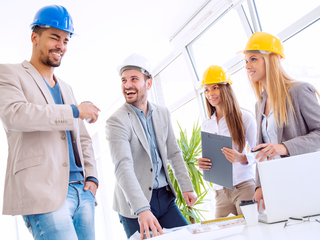 A group of people wearing hard hats discussing wellness improvements in a new construction property.