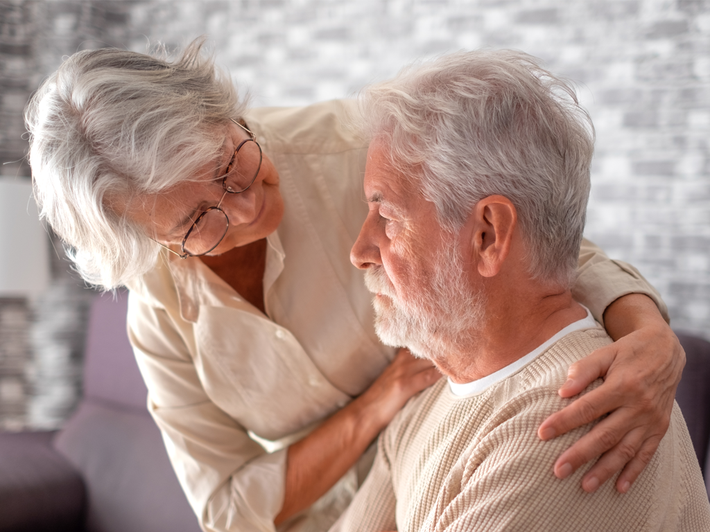 A woman holding her husband, with dementia, shoulders. Dementia has been linked with air pollution and pm2.5.