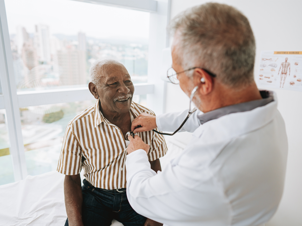 A doctor examining an old person, the healthcare shortage including Drs and nurses are the 4th epidemic which leads to the Quad-demic.