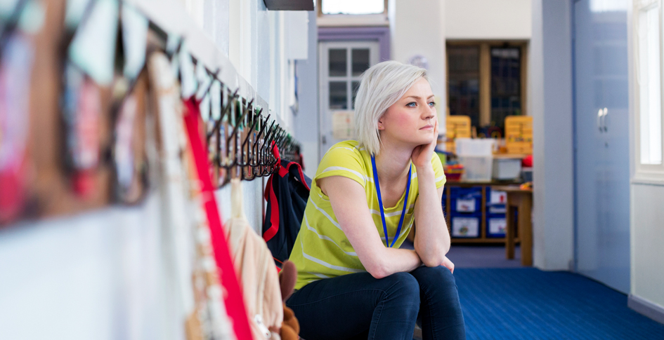 Teacher sitting on a bench with her head resting on her hand, thinking about thinking. Indoor air quality in schools should be thought about and corrected with innovative approaches that do not break the budget of already tight budgets.
