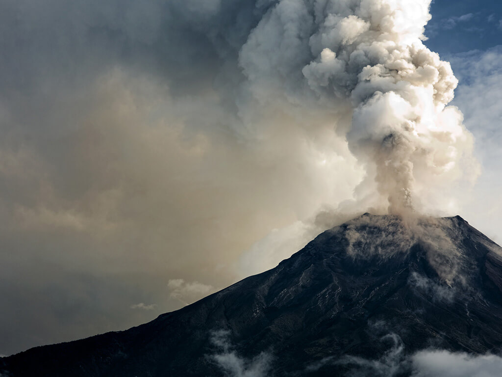 Volcano spewing thick ash which contributes to air pollution and poor air quality in buildings.