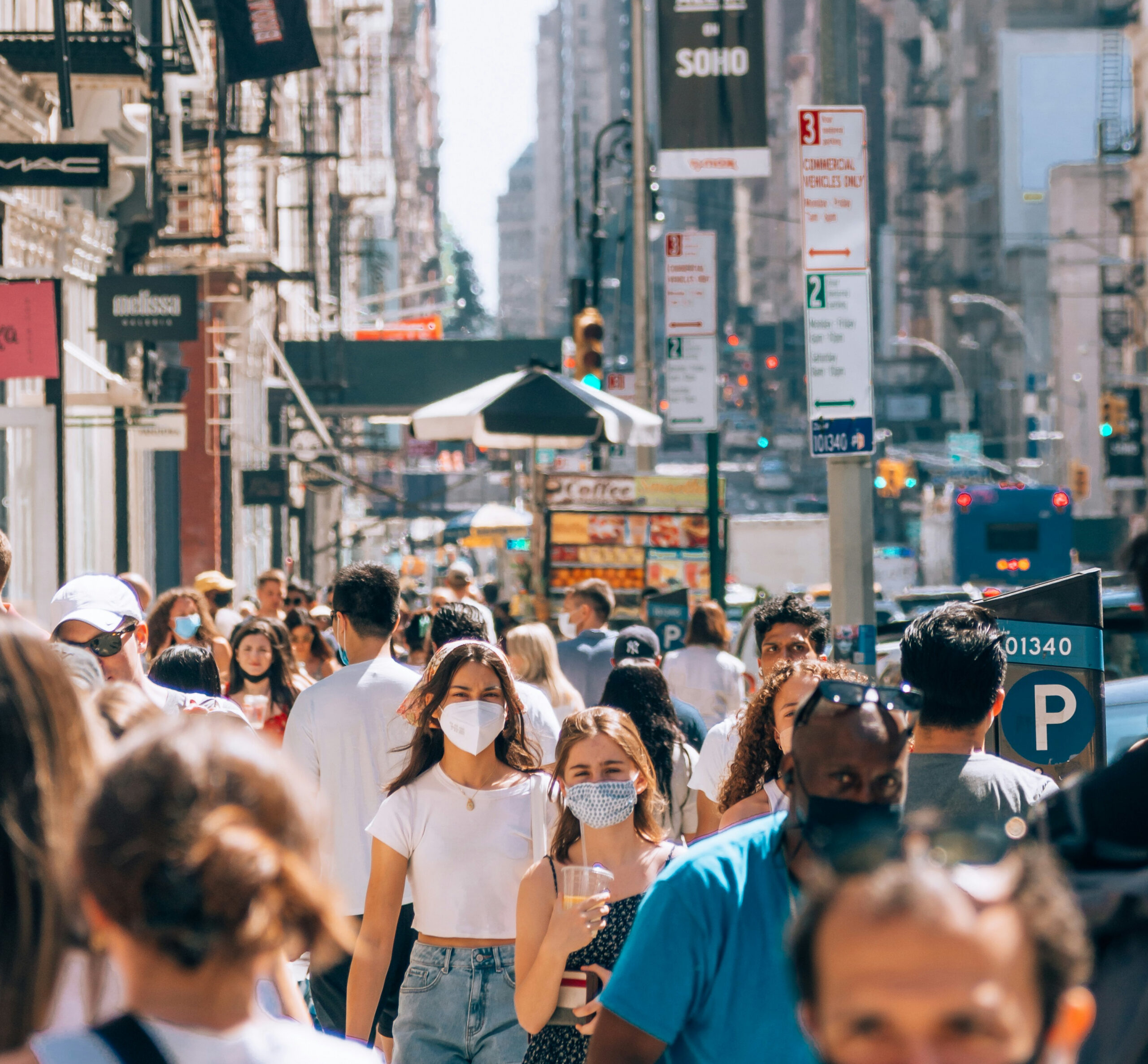 Image of a crowd in a large city wearing masks.