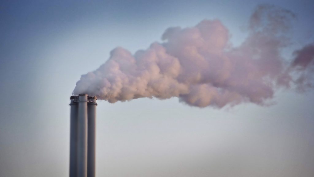 White smoke billowing out of three smokestacks.